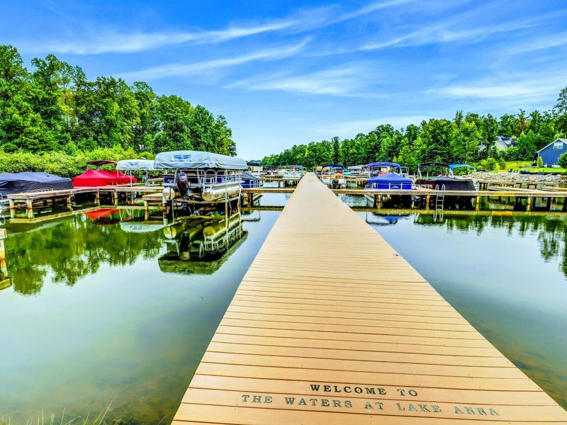 The rental includes access to The Waters community amenities, including a marina, swimming pool, tennis courts, picnic pavilions, a playground, and a sandy beach with lakefront views.