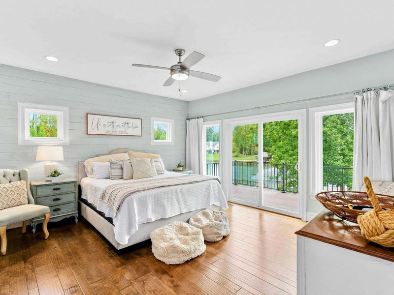A bright and inviting Primary Bedroom featuring a king bed, cozy decor, sliding doors opening to a private balcony with serene views, and an ensuite bathroom.