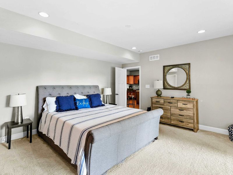 A comfortable bedroom featuring a king bed, stylish decor, sliding glass doors leading to a private patio with outdoor views, and an ensuite bathroom for added convenience.