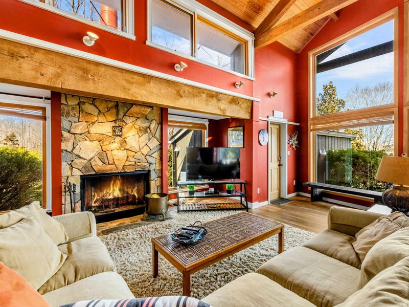 Gather in the inviting Great Room featuring a warm stone fireplace, plush sectional, and large windows showcasing stunning Lake Anna. Relax by the fire, watch your favorite shows, or simply enjoy the natural light in this beautiful waterfront retreat