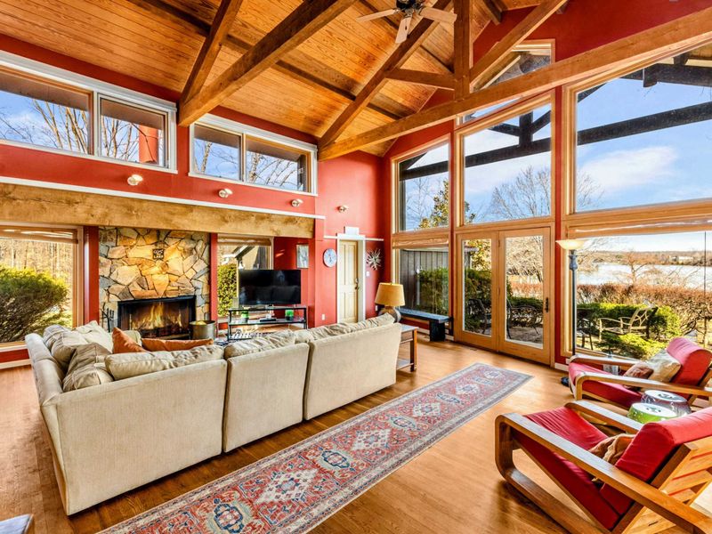 Unwind in the Great Room with soaring wood ceilings, a stone fireplace, and a plush sectional. Floor-to-ceiling windows flood the space with natural light and offer stunning Lake Anna views—perfect for gathering, relaxing, or enjoying the scenery.