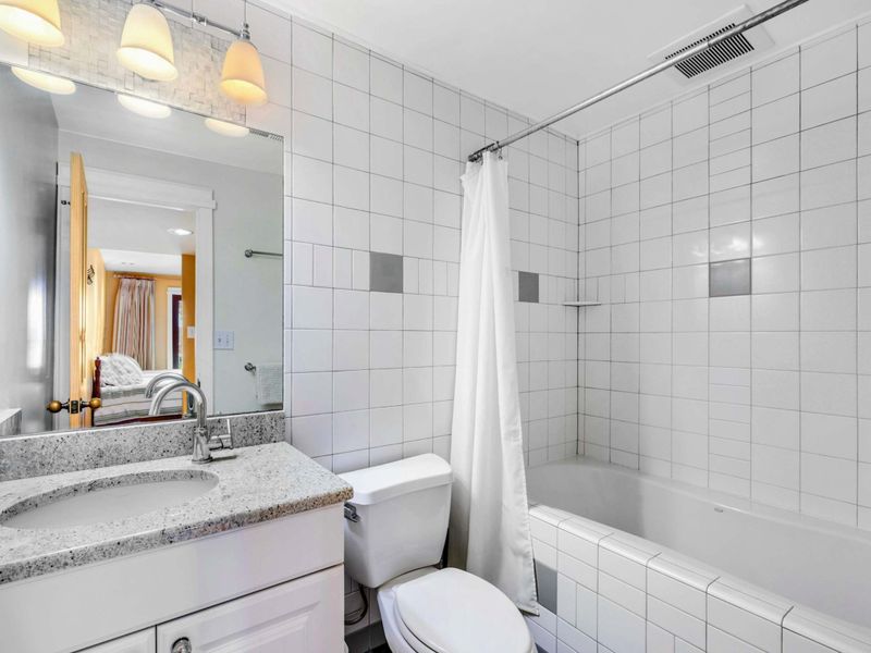 Bedroom 5 Ensuite with Tub & Shower - This private ensuite features a sleek vanity, bright lighting, and a tiled shower-tub combo. A clean and comfortable space, perfect for refreshing after a day at Lake Anna.