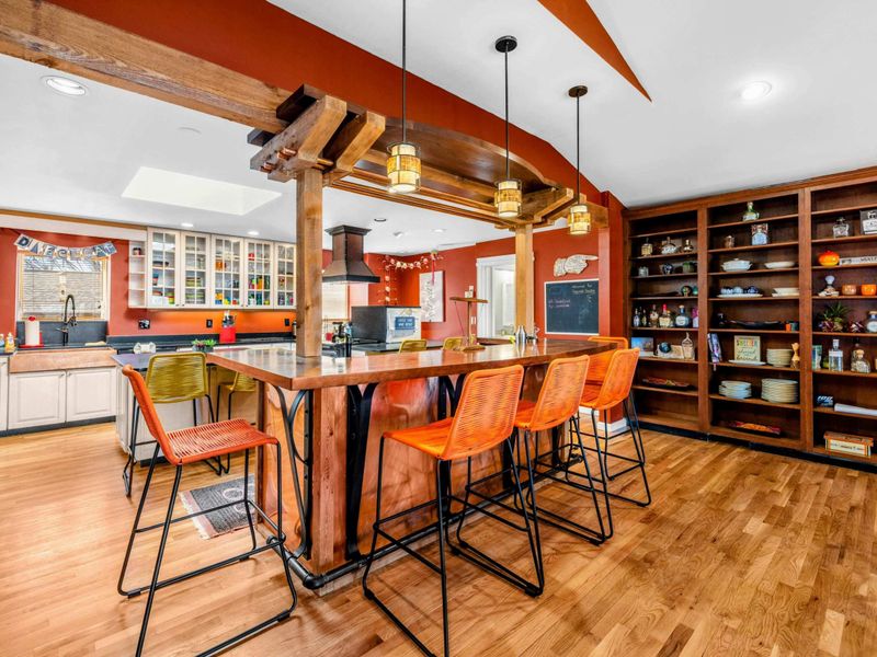 Inviting Kitchen Bar & Open Shelving - This stylish kitchen bar offers seating for six, perfect for gathering and entertaining. Open shelving adds charm and functionality, while warm wood accents create a cozy and welcoming atmosphere.
