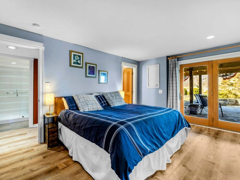 Spacious Bedroom 2 with Ensuite & Patio Access - This bright and cozy bedroom features a plush king bed, an ensuite bathroom, and direct access to a covered patio. Wake up to peaceful views and step outside to enjoy the fresh Lake Anna air.