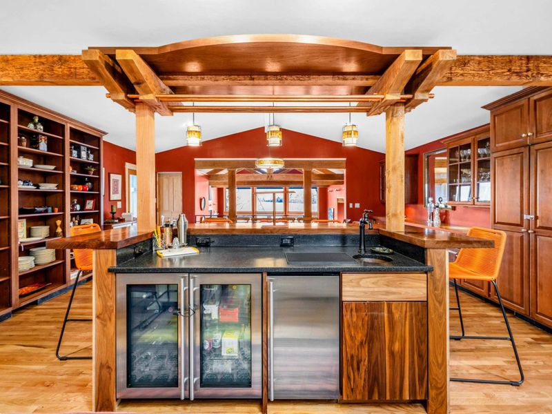 Elegant Wet Bar with Wine Fridge - This beautifully designed wet bar features a wine fridge, sink, and ample counter space for entertaining. With stylish wood accents and open shelving, it's the perfect spot to mix drinks and unwind.