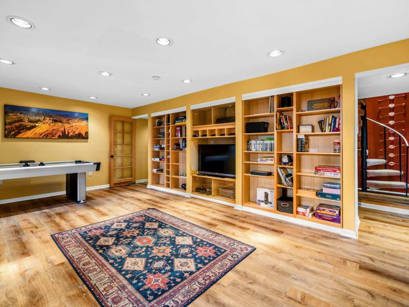 This inviting space features an air hockey table, a TV, and built-in bookshelves stocked with games and books. Perfect for movie nights, friendly competitions, or relaxing after a day on Lake Anna.
