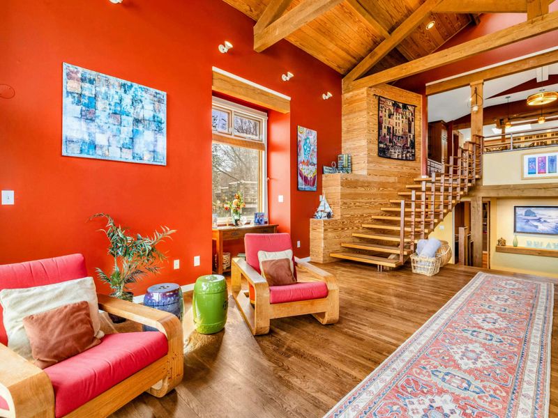This inviting nook features stylish seating, warm wood accents, and abundant natural light. The open-concept layout and modern staircase create a spacious yet cozy atmosphere for relaxation.