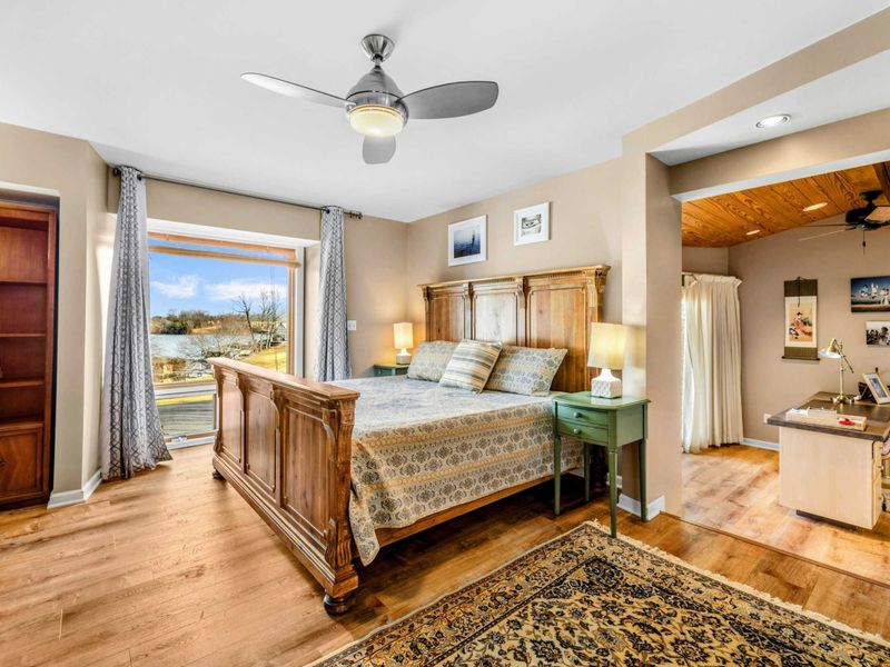 Primary Suite with Office & Private Patio - Wake up to stunning lake views in this spacious Primary Suite featuring elegant wood furnishings, an attached office nook, and direct access to a private patio with a hot tub for ultimate relaxation.