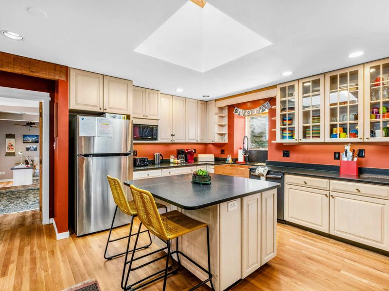 Bright & Spacious Kitchen - This fully equipped kitchen features modern appliances, ample counter space, a center island with seating, and glass-front cabinets. Perfect for preparing meals and gathering with family and friends.