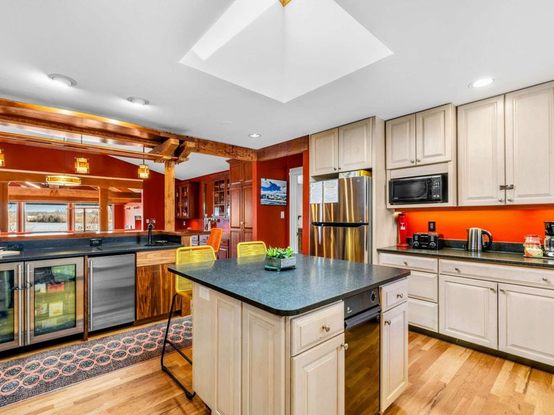 Fully Equipped Kitchen with Bar & Island - This bright and open kitchen features modern appliances, a wine fridge, and a spacious island. The open layout flows into the bar and dining area, making it perfect for cooking and entertaining.