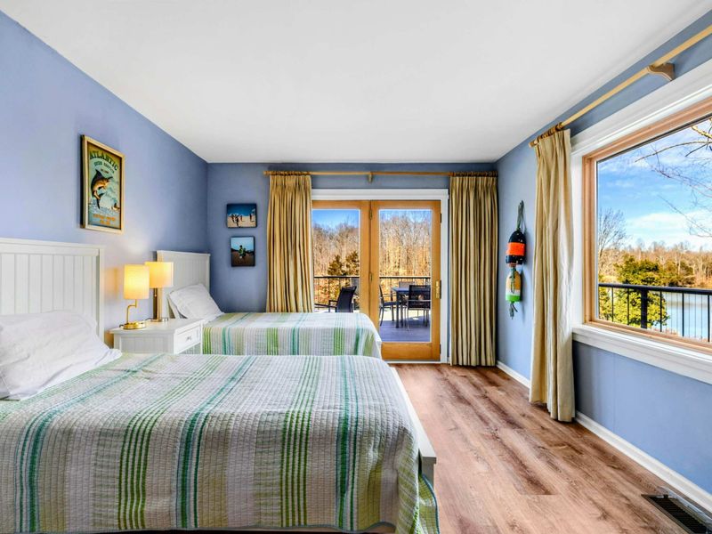 Bright Bedroom 3 with Lake Views & Deck Access - This charming bedroom features two cozy twin beds, large windows with stunning lake views, and direct access to a private deck. A perfect space for relaxation and enjoying the fresh Lake Anna breeze.