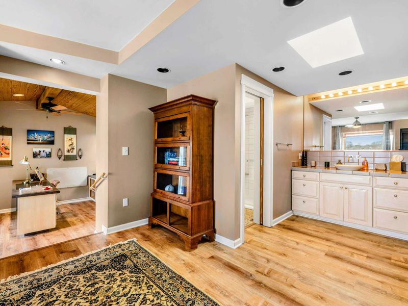 Primary Suite with Office & Ensuite - This spacious Primary Suite features a private office nook, a luxurious ensuite with dual vanities, and a walk-in shower. Thoughtful design and warm wood tones create a perfect retreat for work and relaxation.