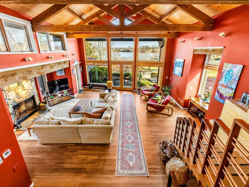 Enjoy breathtaking Lake Anna views from this spacious Great Room featuring soaring wood ceilings, a cozy stone fireplace, and floor-to-ceiling windows. The perfect spot to relax and unwind.
