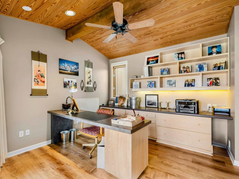 Private Office with Warm Wood Accents - This quiet and cozy office space features a spacious desk, built-in shelving, and warm wood ceilings. A perfect spot for remote work or writing, with easy access to the private patio and lake views.