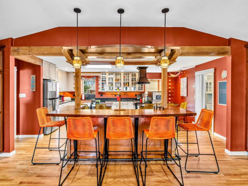 Stylish Kitchen Bar & Gathering Space - This spacious kitchen bar offers seating for six, perfect for casual meals or entertaining. Warm wood beams, elegant lighting, and an open layout create a welcoming atmosphere for friends and family.