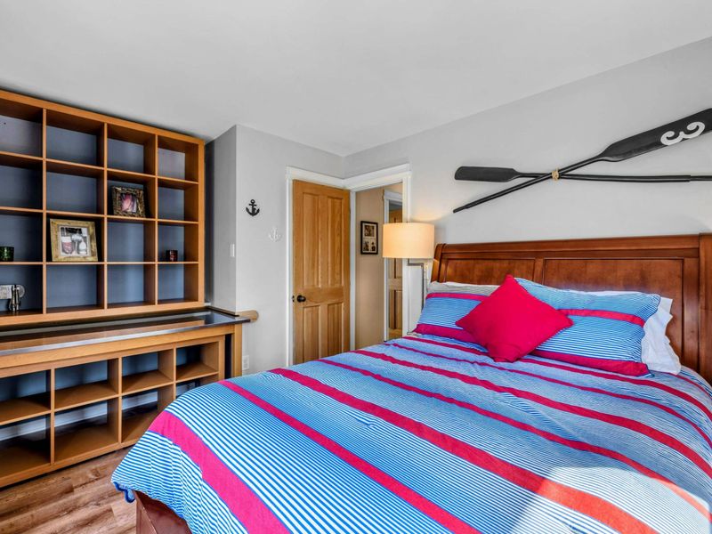 Cozy Bedroom 4 with Built-In Shelving - This inviting bedroom features a plush bed, nautical decor, and built-in shelving for extra storage. A perfect retreat with warm lighting and a relaxing atmosphere near Lake Anna.