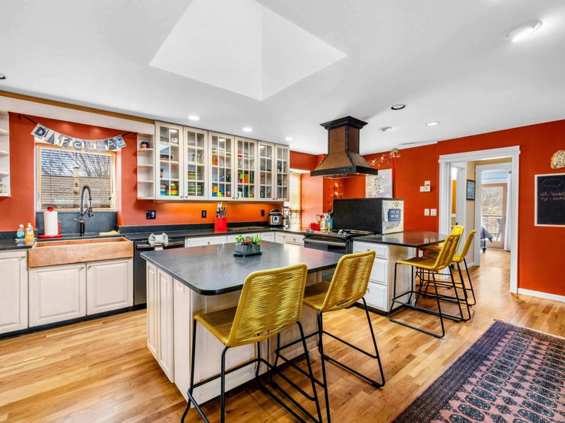 Spacious Gourmet Kitchen - This bright and open kitchen features dual islands, modern appliances, and ample seating. With open shelving, a farmhouse sink, and stylish accents, it's perfect for cooking, entertaining, and gathering.
