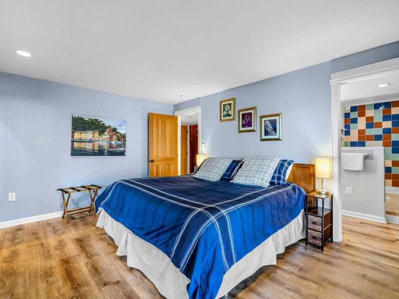 Cozy Bedroom 2 with Ensuite & King Bed" - This charming bedroom features a plush king bed, warm decor, and an attached ensuite with colorful tile accents. A peaceful retreat for restful nights after a day at Lake Anna.