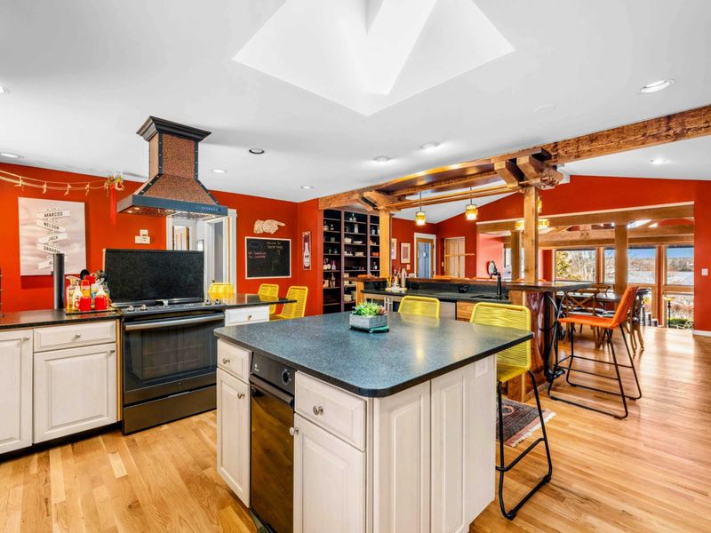 Bright & Open Gourmet Kitchen - This spacious kitchen features dual islands, modern appliances, and rustic wood accents. Designed for cooking and entertaining, it seamlessly flows into the dining and living areas with stunning lake views.
