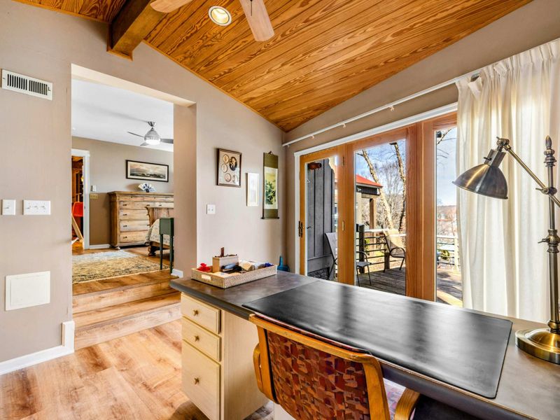 Private Office with Patio Access - Work in comfort with this serene office nook featuring a spacious desk, warm wood accents, and natural light. Step outside through the sliding doors to a private patio with a hot tub and lake views.