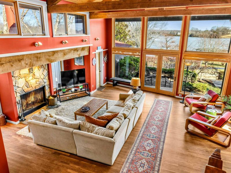 Soaring ceilings, a cozy stone fireplace, and floor-to-ceiling windows frame stunning Lake Anna views. Relax in the spacious seating area or step outside to enjoy the beauty of the waterfront.