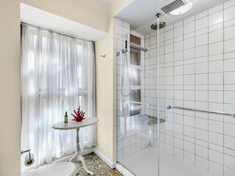 Spa-Like Ensuite with Walk-In Shower - This bright and airy ensuite features a sleek glass-enclosed walk-in shower with a rainfall showerhead, elegant tilework, and natural light, creating a relaxing and refreshing retreat.