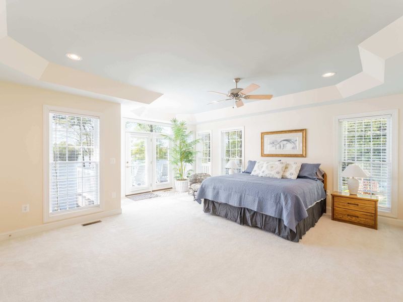 The giant primary suite! This room has a comfortable, king sized bed, a private deck that overlooks the gorgeous lake (with seating) and a stunning bathroom with his and her sinks. You will never want to leave after staying in this room.