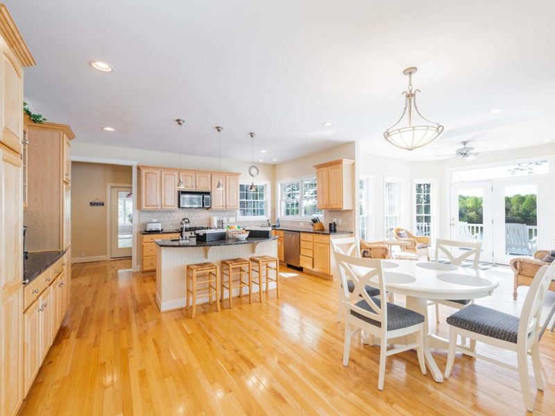 A view of the expansive kitchen from the living room. The formal dining room is to the left and there is a 4 person table and barstool, island seating in the kitchen as well so that everyone can be involved!