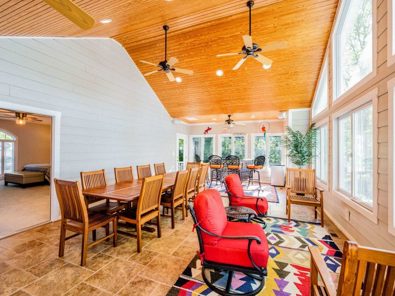 The SUN room features a spacious dining table, comfortable seating, and high ceilings, making it the perfect space for large dinners, board games, and fun for the adults!