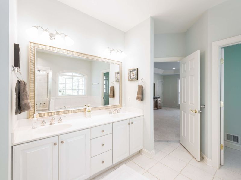 Large primary bathroom with his and her sinks, soaking tub and stand up shower. Impeccably cleaned and stocked with shampoo, conditioner, body wash, a blow dryer, and more.