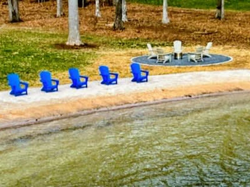 Lakeside Lounging & Fire Pit: Relax in vibrant Adirondack chairs along your private sandy shoreline, or gather just steps away at the lakeside fire pit for cozy evenings by Lake Anna.