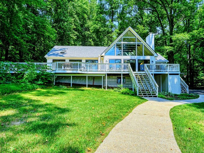 Lakeside Cottage: The charming, white lake house, beautifully framed by nature and Lake Anna views.