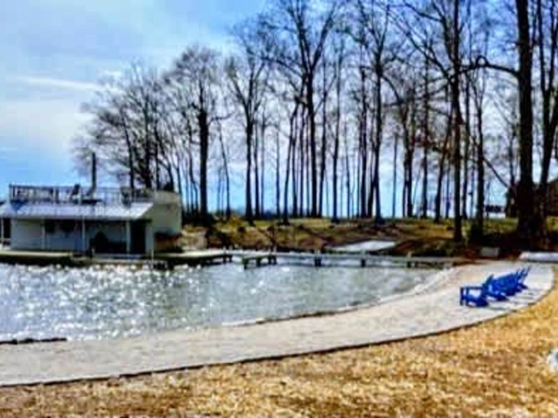 Private beach and dock: A gently curving sandy shoreline leads to your private dock on Lake Anna, with Adirondack chairs and a nearby fire pit offering the perfect place to unwind.
