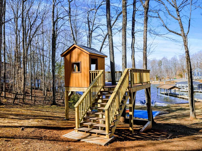 Adventure Awaits – A rustic treehouse nestled among the trees with lake views.