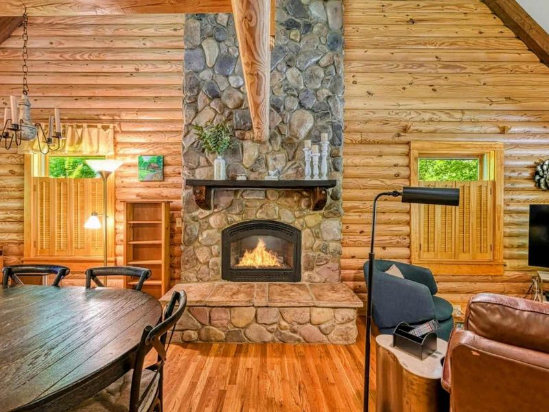 Cozy up by the beautiful stone fireplace in this charming log cabin, perfect for relaxing after a day of lakeside adventures.