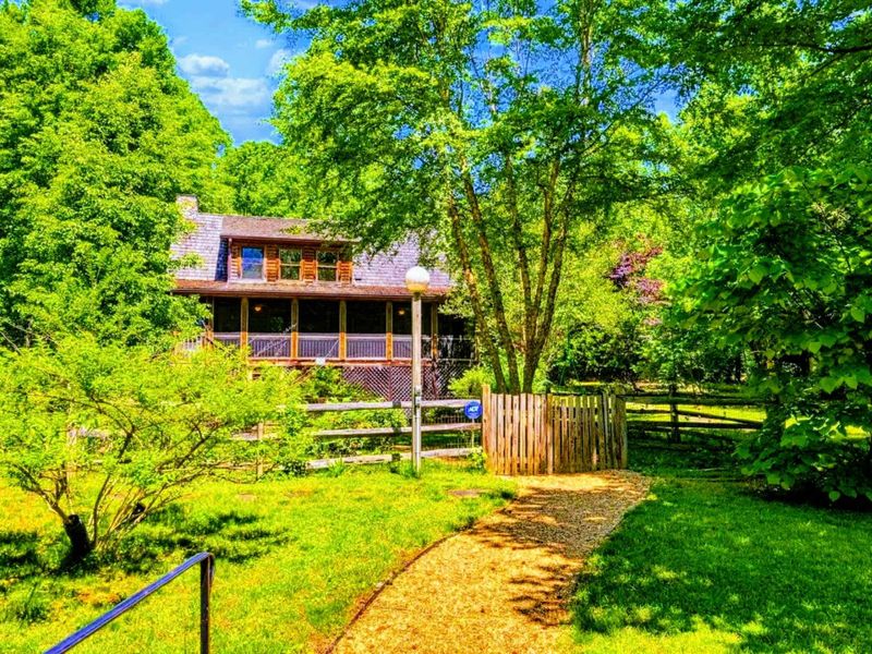 Follow the charming path through lush greenery to this cozy retreat, offering a perfect blend of nature and comfort.