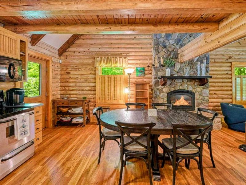 Enjoy a warm meal by the fire in this rustic log cabin kitchen, where cozy meets comfort for your perfect getaway.