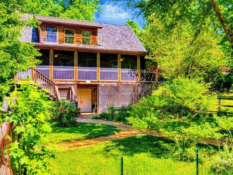 Experience the charm of this cozy cabin retreat, surrounded by lush greenery and just steps from the lake, perfect for a peaceful getaway.
