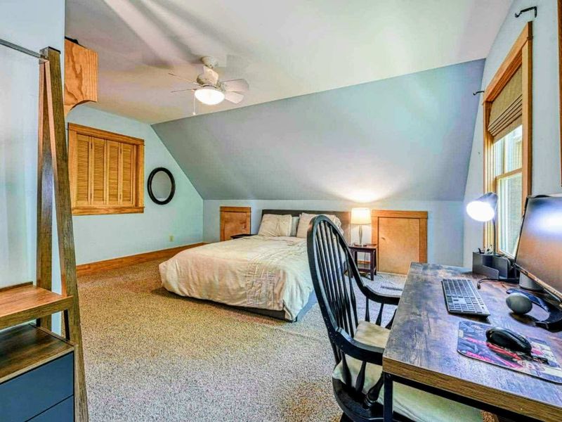 Unwind in this spacious bedroom featuring a cozy work desk, perfect for balancing relaxation and productivity during your getaway.