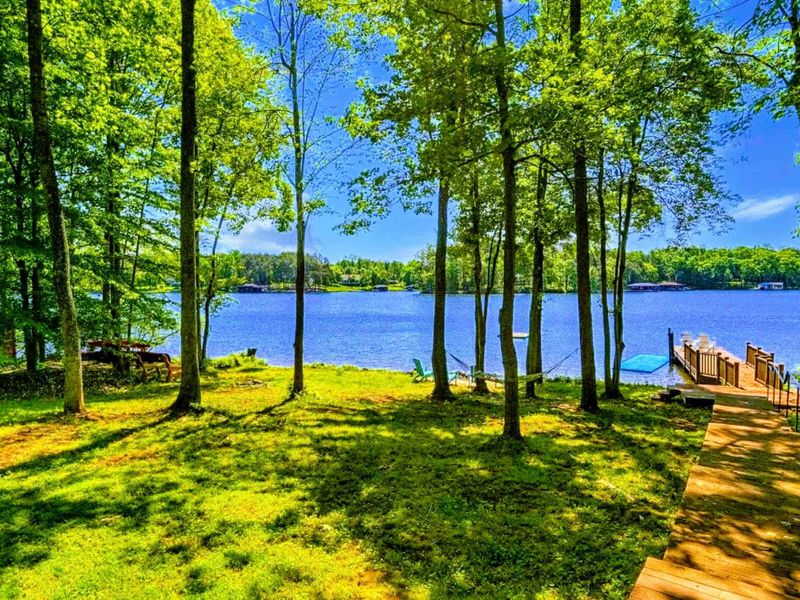 Relax under the shade of the trees in this expansive lakeside yard, with easy access to your private dock and stunning water views.