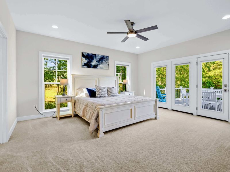 Primary Suite - King bed, French doors to the back deck, and tall windows that frame the treetops, the reward at the end of the day.