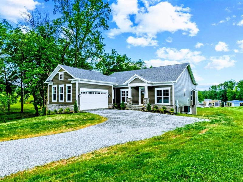Exterior - Modern lake house tucked into mature greenery, with outdoor living that flows from deck to lawn to dock.