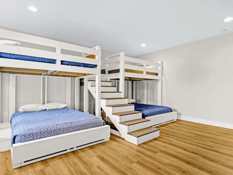 Bunk Room - Custom-built triple bunk wall sleeps the kids in style, with navy bedding and steps up to the lofted tops.