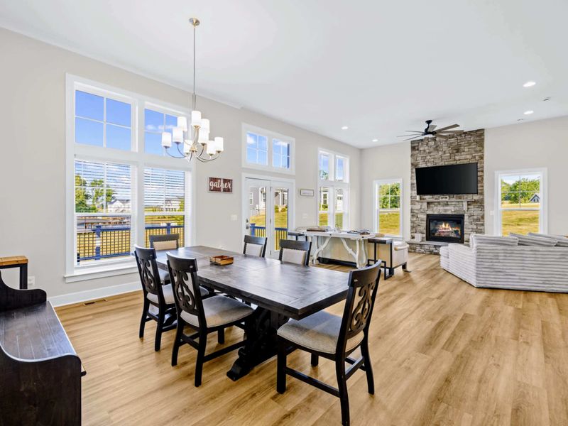 Dining Area - Six-seat farmhouse table catches the morning light, set between the deck doors and the stone fireplace lounge.