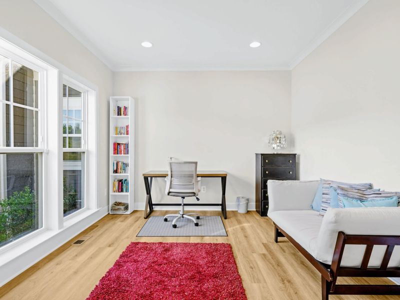 Office - Desk, ergonomic chair, and futon by the big window, with built-in bookshelves stocked for a slower morning.