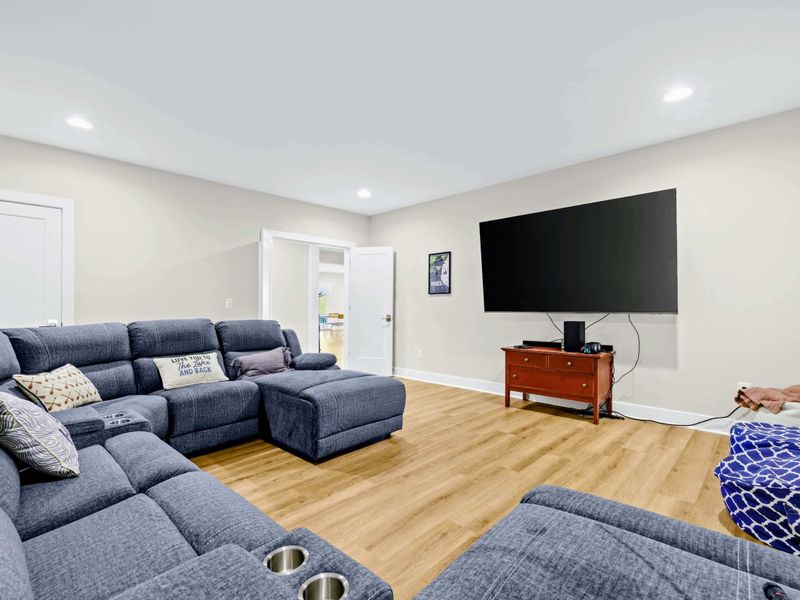 Theater - The curved sectional with built-in cup holders faces the mounted big screen for a true couch-cinema experience.