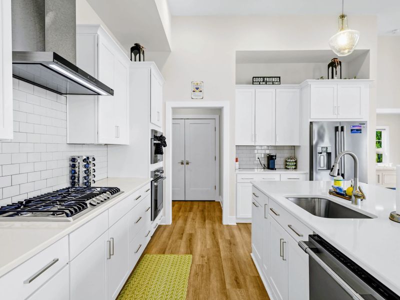 Kitchen - Five-burner gas cooktop, double wall ovens, and a walk-in pantry close at hand for whoever is in charge of dinner.