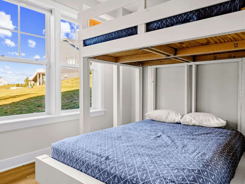 Bunk Room - Lower queen bunk with window views out to the yard, a quiet retreat tucked under the lofted top.