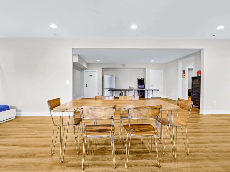 Game Room - The six-seat dining table looks toward the ping pong and arcade, with the bunk room peeking in on the left.