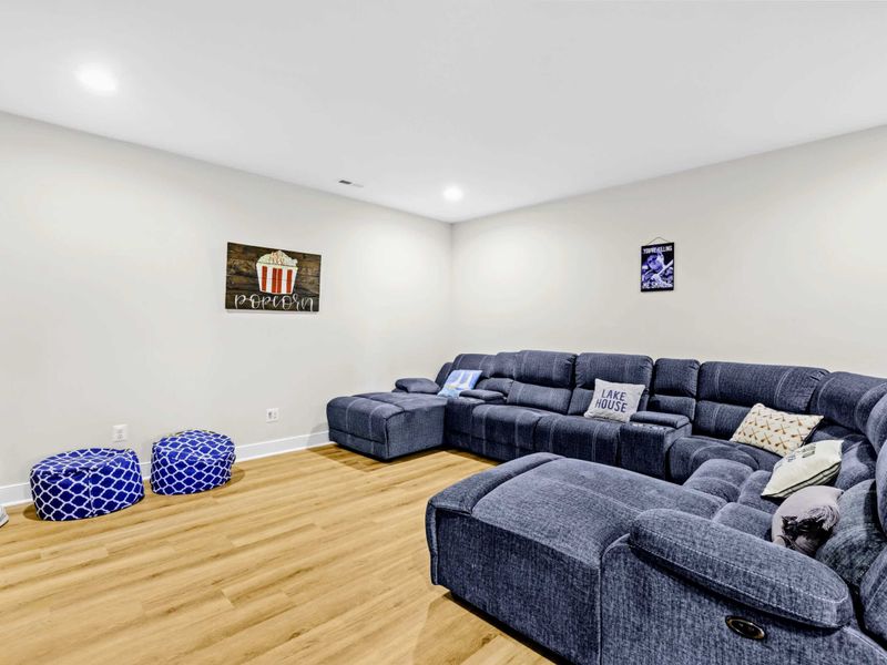 Theater - Oversized sectional with built-in recliners and a Lake House pillow, set up for movie nights and Saturday games.
